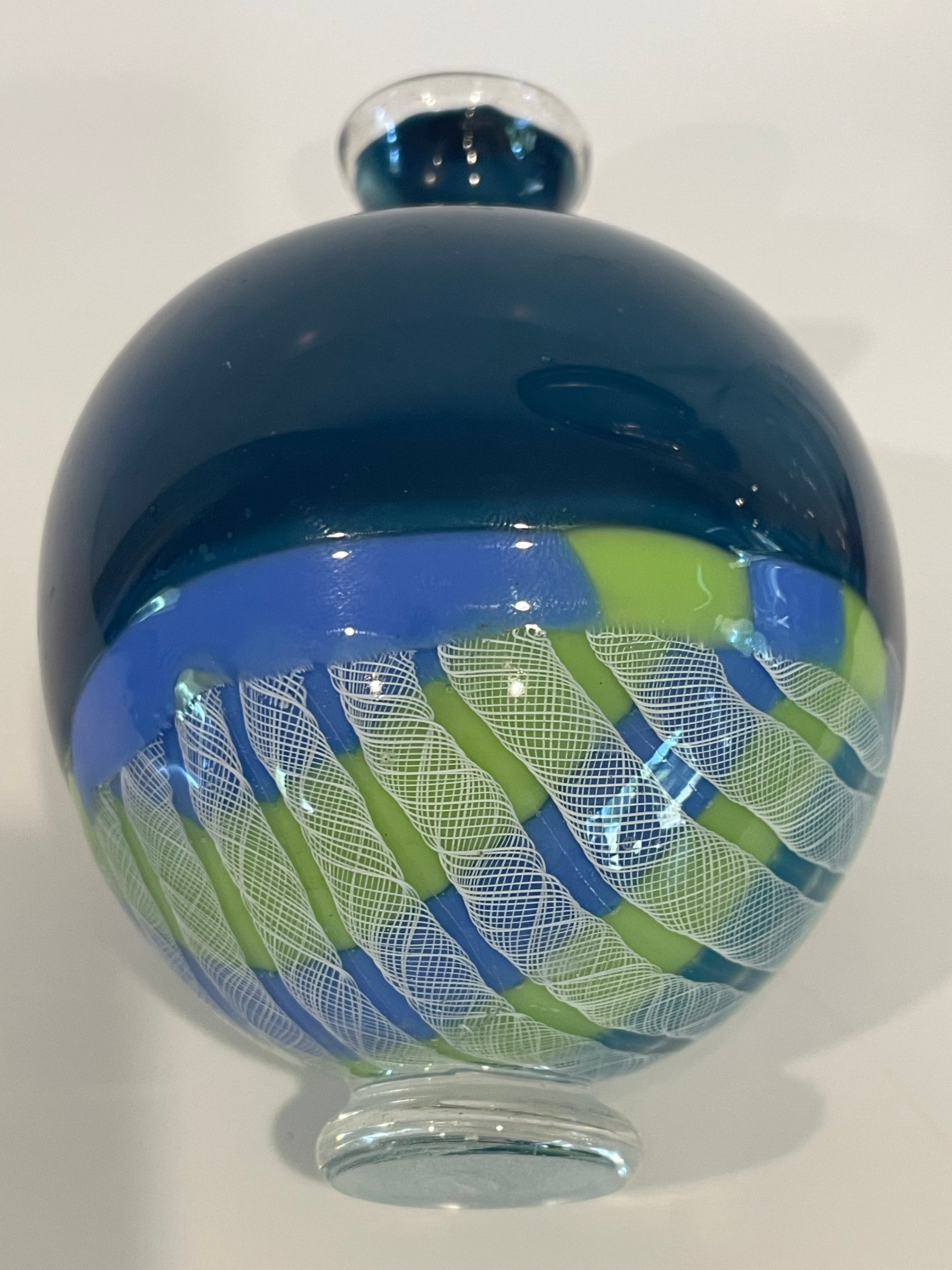 Blue and green blown glass vessel with white cane stripes