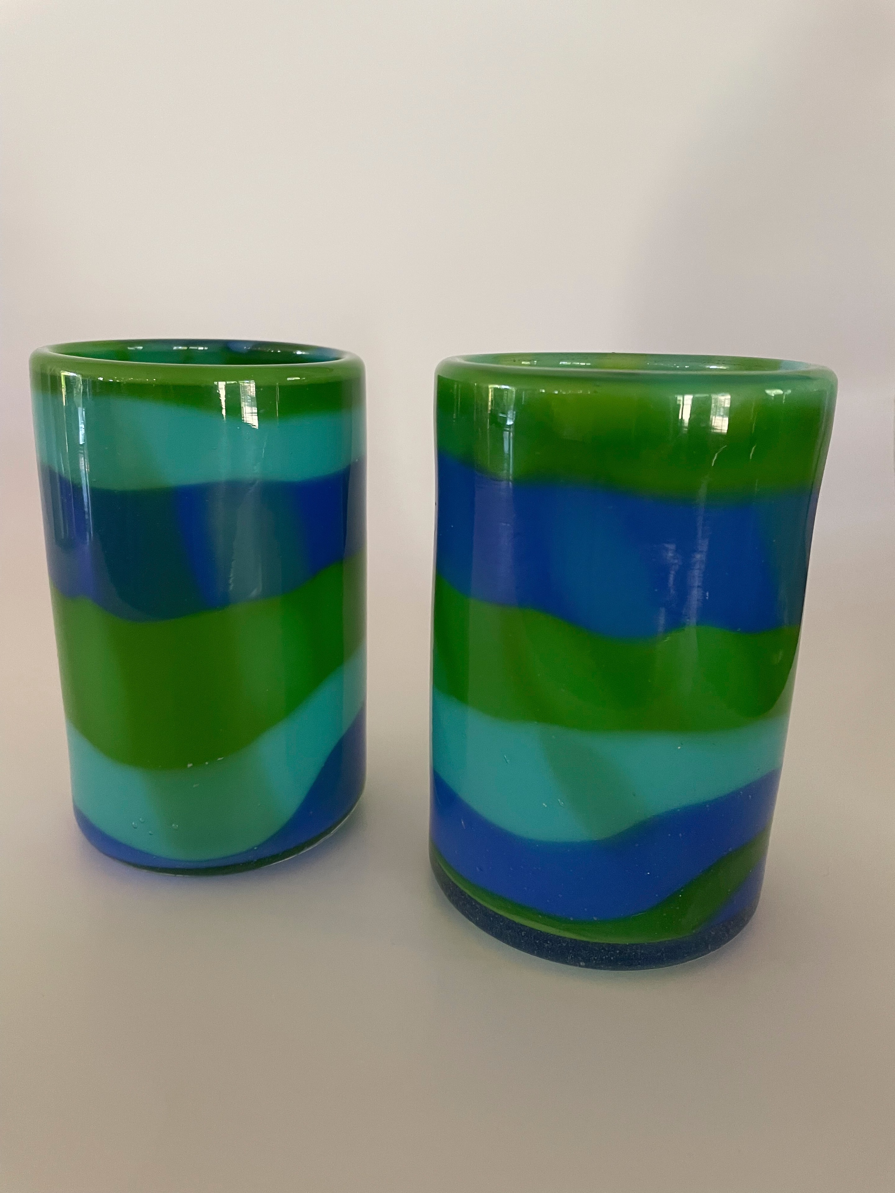 Pair of blown glass vessels with layered green, teal, and blue stripe pattern