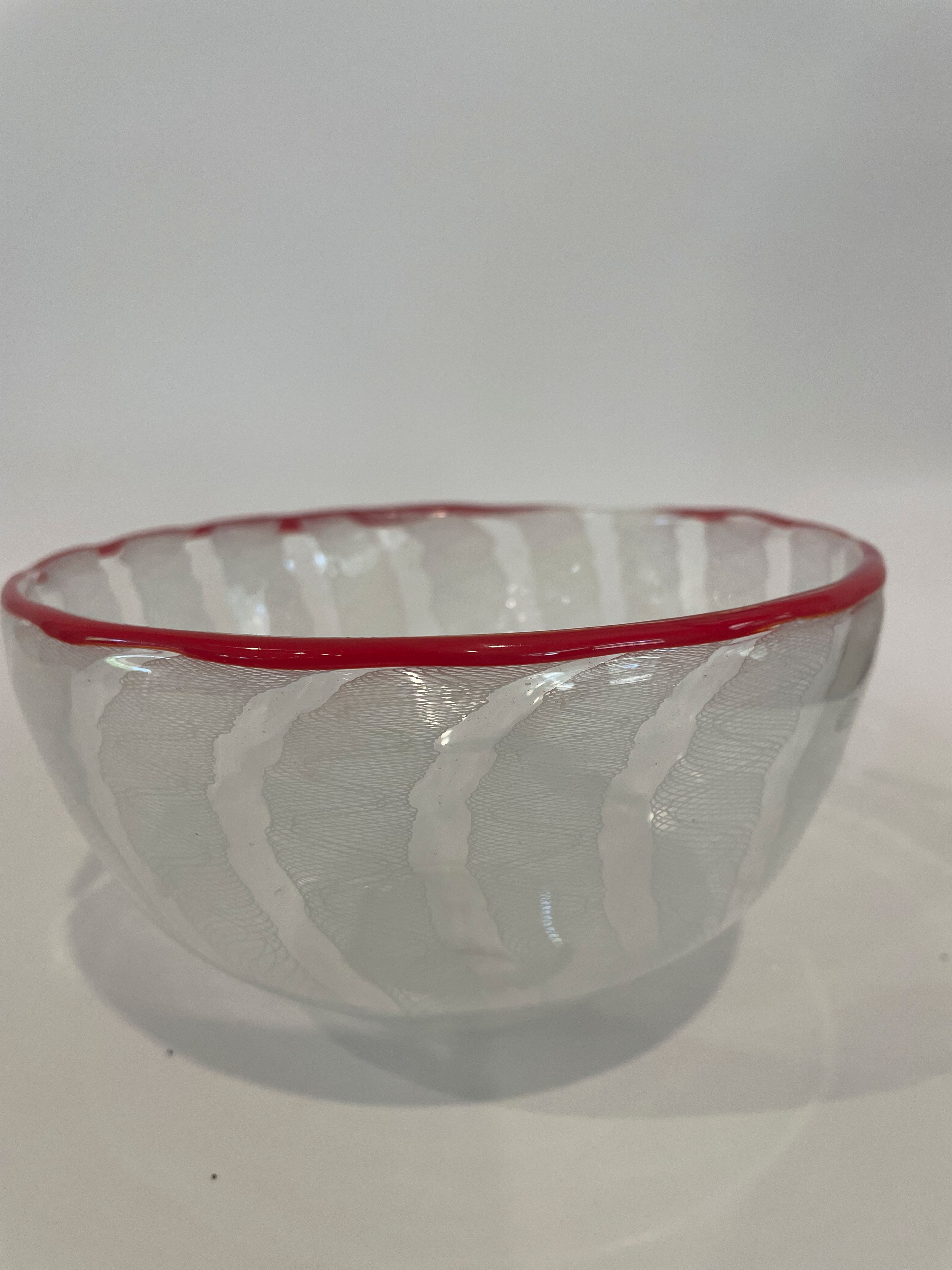 Clear blown glass bowl with white latticino cane pattern and red rim