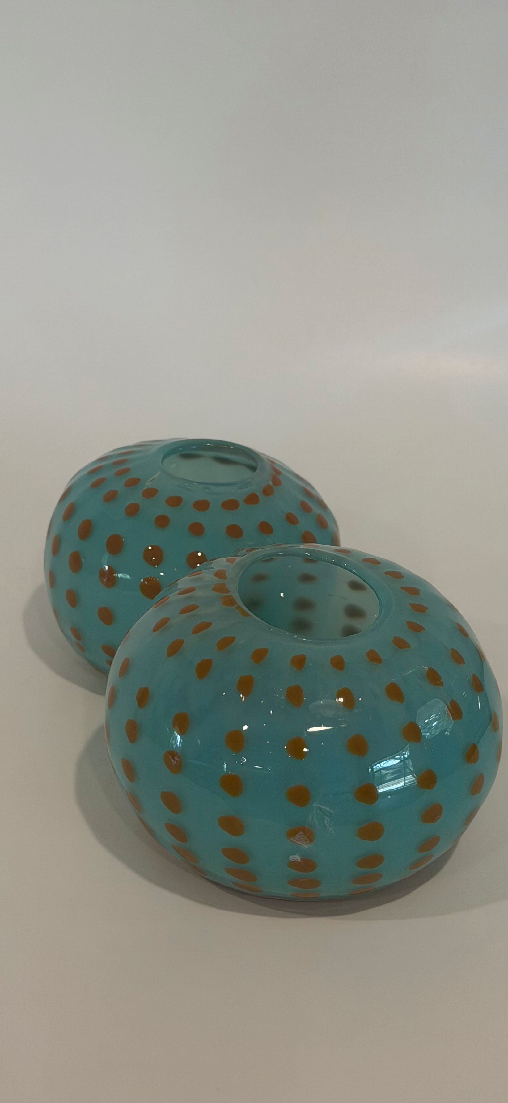 Pair of turquoise blown glass urchin vessels with amber dot pattern